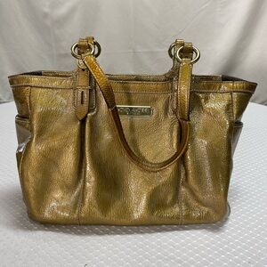 Preowned Gold Coach purse. notes: 2 minor scuffmarks; lining has some ink marks.